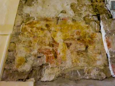 ...e una pittura in cui si intravede Cristo in abito porpora che regge la croce